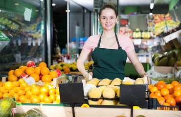 saleswoman standing behind the counter with  fruit
