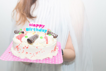 Birthday. Girls with a cake with candles,Young woman holding plate with tasty birthday cake .