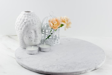 white ceramic figurine Buddha head  ,decorative cage with flowers and candles