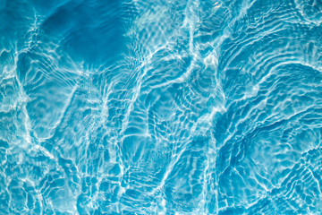 Background of rippled pattern of clean water in a blue swimming pool