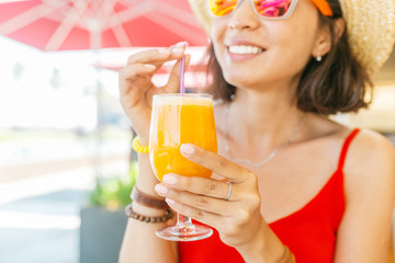 young woman drinking orange juice at restaurant bar