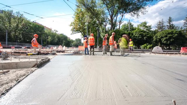 Concrete works for road construction with many workers and mixer timelapse hyperlapse