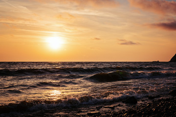 Minimalistic natural violet-orange sunrise over the sea with waves