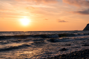 Bright pink-orange dawn over water storm wind with waves