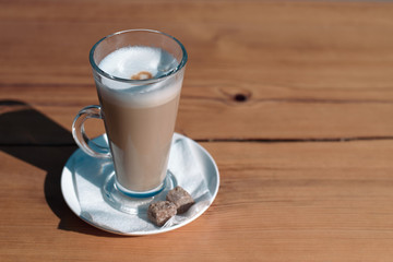 Top view of a mug of latte with cane sugar on a wooden table