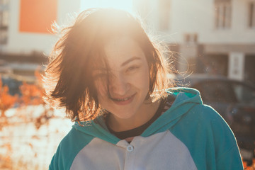 beautiful cute young woman portrait in blue fleece jacket with contoured sunlight