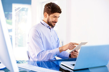 Businessman using digital tablet while working in the office