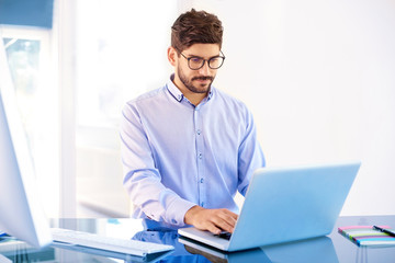 Young businessman working on laptop in the office