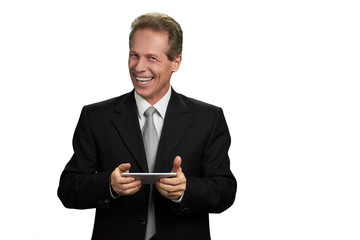 Portrait of happy businessman with smartphone. Laughing male executive holding smartphone isolated on white background with copy space.
