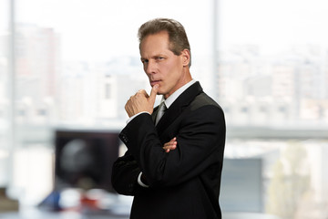 Confident businessman looking thoughtful. Portrait of serious thinking executive, side view.