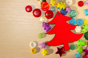 Fototapeta na wymiar Holidays, Hobby, Handmade, Christmas, Fine Arts Concept. Red Wooden Christmas Tree And Colorful buttons Over Wooden Background With A Lot Of Copy Space For Text. 