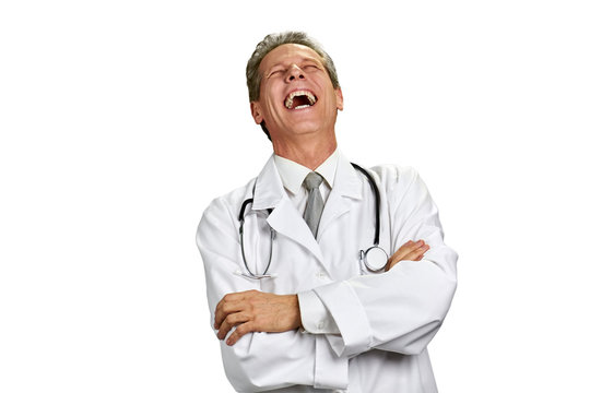 Laughing doctor isolated on white background. Portrait of laughing physician in white coat with arms crossed, copy space.