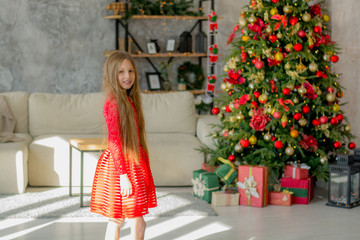 Fototapeta na wymiar Beautiful girl near the Christmas tree with gifts