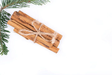 Winter holiday decoration: fraser fir twig and cinnamon sticks tied with jute rope isolated on white background