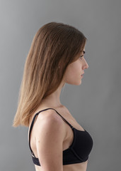 Fototapeta premium Standard model tests of young pretty woman on a gray background,Test Shots young models for modeling agency on a gray background with ,young beautiful woman in underwear. portrait of slim woman 