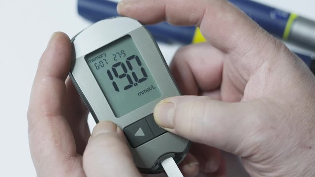 Patient with diabetes using blood glucose meter. Viewing blood glucose results