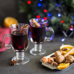 Red mulled wine in glasses with electric lights at dark background
