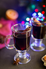 Red mulled wine in glasses with electric lights at dark background