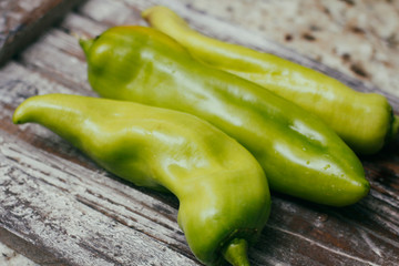 Set of green sweet peppers on wooden table. Fresh raw vegetables.