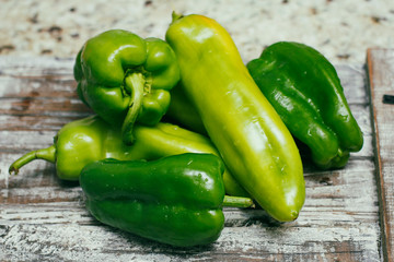 Set of green sweet peppers on wooden table. Fresh raw vegetables.
