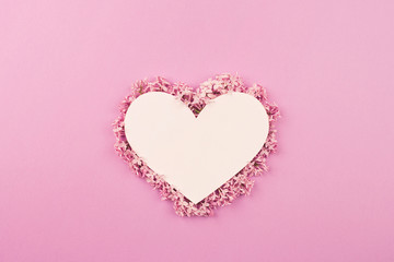 white heart decorated with lilac flowers on pink background. Card for Valentine's day, mother's day, women's day with love