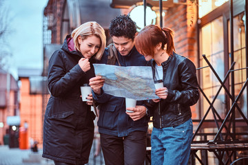 Group of tourists searching place on the map