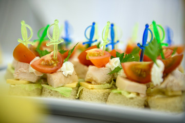 Canapes with cheese and tomatoes. Cold appetizer for wine at the party.
