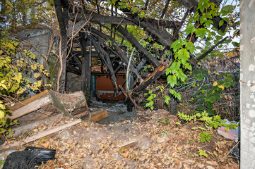 Ruined and collapsed house burnt and damaged in the fire with remains of the wooden reinforcement poles of roof selective focus