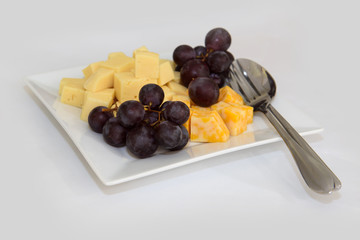 Dish with cheese and grapes. Cold appetizer for wine.