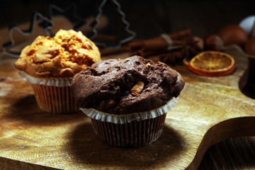 Chocolate muffin and nut muffin, homemade bakery wooden background