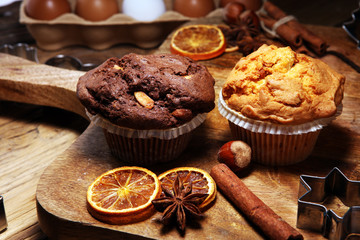 Chocolate muffin and nut muffin, homemade bakery wooden background