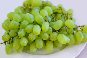 Bunch of green Grapes on a plate. Useful berries and fruits for vegetarian food. 