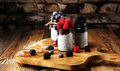 Healthy breakfast. chia pudding with kiwi and granola in glass on rustic background.