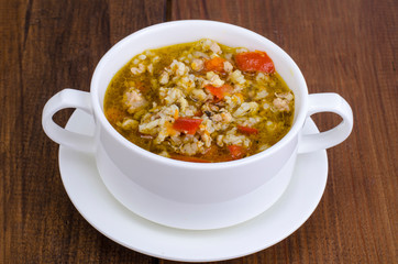 White bowl of chicken and wild rice soup with vegetables