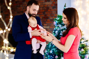 Mother giving Christmas present to her baby child