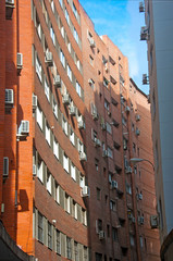 Orange brick building with concave wall, vertical view