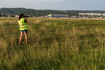 A photographer takes photos of take-off and landing planes.
