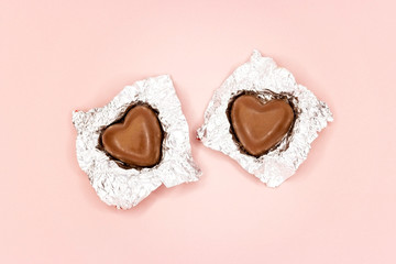 Chocolate hearts in foil on pink background