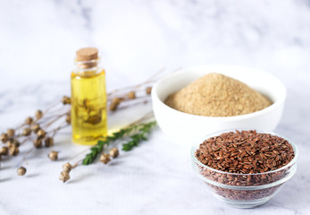 Flax seeds, flax flour, oil with sprouts and flax seed boxes on a light background.