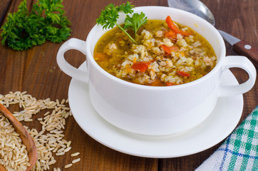 White bowl of chicken and wild rice soup with vegetables