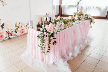 festive table for the bride and groom decorated with cloth and flowers