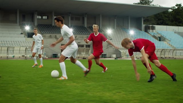 Moving Shot of Professional Soccer Player Leads with a Ball, Masterfully Dribbling and Bypassing Sliding Tackles of His Opponents. in Slow Motion.