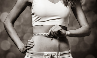Beautiful and strong women's abs with measuring tape. Image in black and white color style