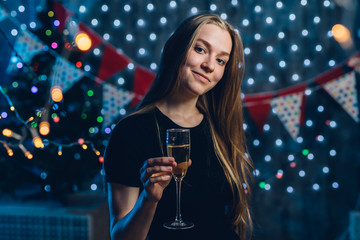 Young woman with a glass of champagne. Celebrating new year, christmas