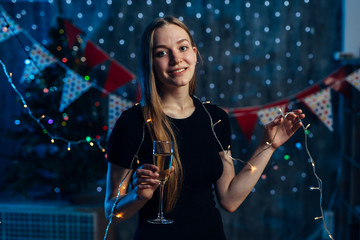 Young woman with a glass of champagne. Celebrating new year, christmas