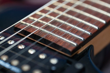 Fototapeta premium guitar with wooden brown neck and strings, close up blurry background, texture, abstract