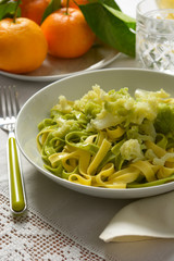 egg noodles with cauliflower and tangerines on the background