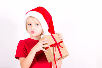 Happy boy in Santa red hat holding Christmas gift in hand. Christmas concept.