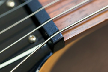 guitar  with wooden brown neck and strings, close up blurry background, texture, abstract