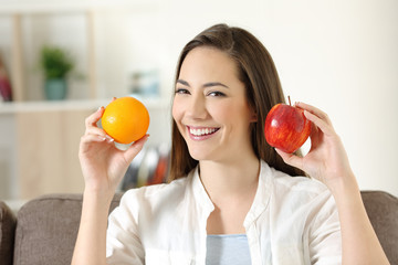 Girl showing apple and orange fruits